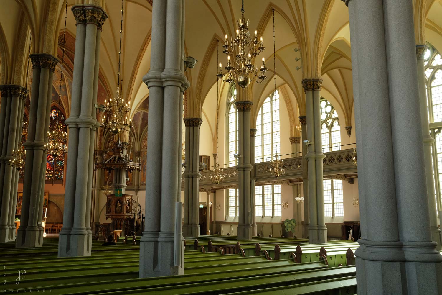 Graue, schlanke, hochaufschießende Bündelsäulen mit filigranem, beige-gelbem, gotischem Gewölbe - dabei weiches Licht mit sanften Schatten- und Lichtbereichen.